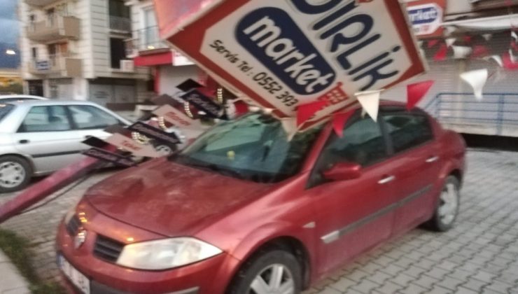 Hatay’da fırtınada reklam direği otomobilin üzerine devrildi