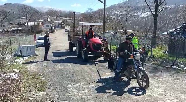 Yolda kalan traktörü motosiklet ile çektiler